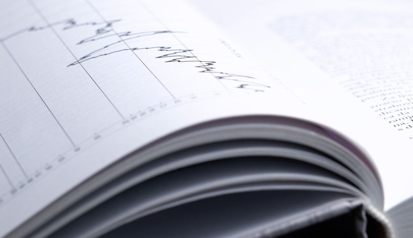 Closeup of the investment analysis book with a graph.